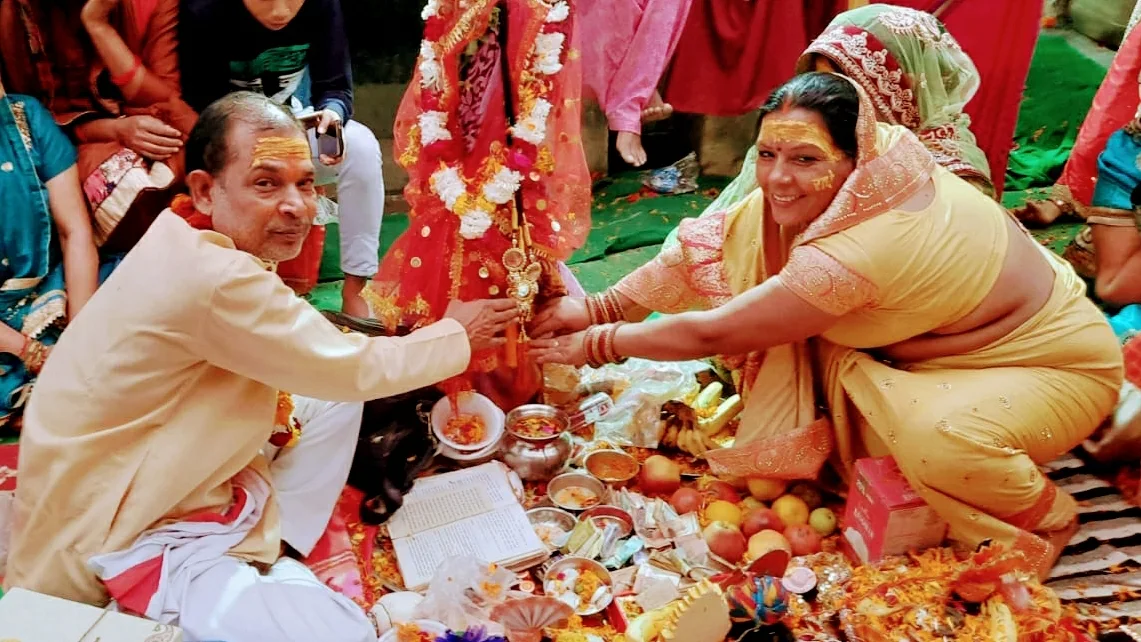 Couple performing traditional Hindu puja ceremony with offerings and flowers — Pandit Ji Pooja Delhi NCR